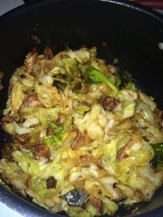 some food is cooking in a skillet on the stove top and ready to be cooked