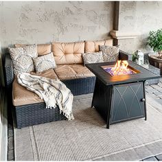 a living room with couches and a fire pit on the floor in front of a wall