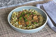 a bowl filled with rice and meat on top of a table