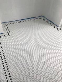 an empty bathroom with black and white tiles on the floor is shown in this image