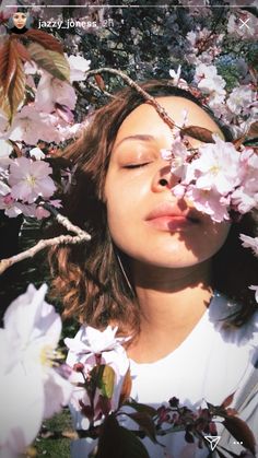 a woman with her eyes closed is surrounded by flowers