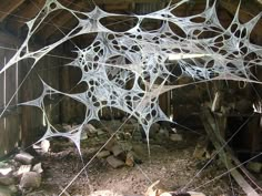 the spider web is hanging upside down on the ground in an old barn with wood and logs