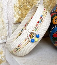 two colorful baskets sitting on top of a white counter next to a stone wall and rock