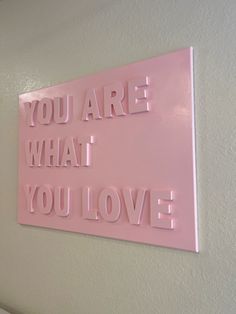 a pink sign that says you are what i love on the side of a wall