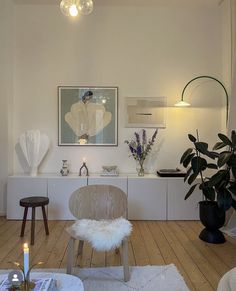 a living room filled with furniture and a painting hanging on the wall next to a window