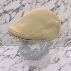 a hat is sitting on top of a mannequin's head in front of a marble wall