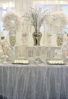 a table topped with lots of silver and white decorations