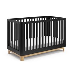 a black crib with white sheets on it