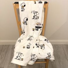 a chair with a blanket on top of it that has snoopy dogs all over it