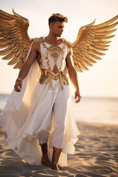 a man dressed in white and gold with wings on his head, standing on the beach