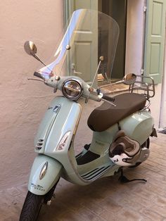 a scooter parked on the sidewalk in front of a building with a door