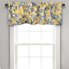 a yellow and blue flowered valance hangs over a window with white curtains in front of it