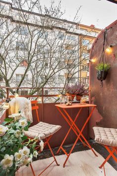 an outdoor patio with two chairs and a small table on the floor next to it