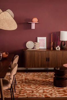 a living room with purple walls and furniture in the corner, including a wooden cabinet