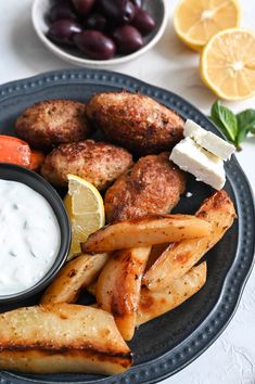 a blue plate topped with meatballs and fries next to a bowl of ranch dressing