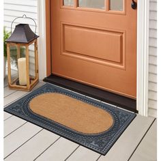 a door mat with a lantern on the front porch