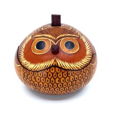 an orange and brown owl shaped box with two eyes on it's face, sitting on a white surface