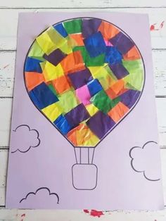 a paper hot air balloon with clouds on the bottom and rainbow colors in the middle