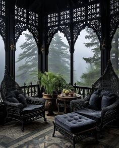 an ornate gazebo with black furniture and potted plants on the balcony overlooking foggy trees