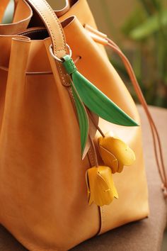 a brown leather bag with yellow flowers in it