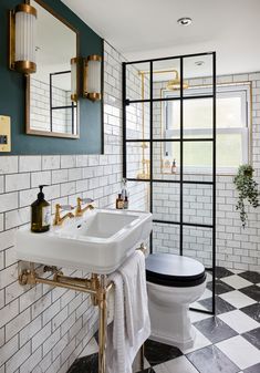 a white toilet sitting next to a black and white checkered floor in a bathroom