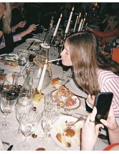 a group of people sitting at a table with food and drinks in front of them