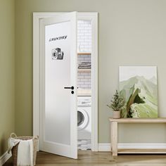 an open door to a room with a washer and dryer on the floor