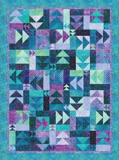 a blue and purple quilt with an abstract design on the front, in different colors