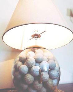 a lamp that is on top of a table with golf balls in the ball bowl