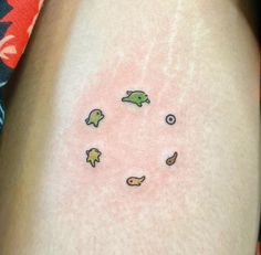 a person with a small tattoo on their thigh that has fish and leaves all over it