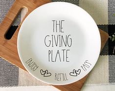 a white plate with the words, the giving plate and an empty bowl on it