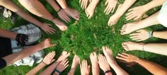 a group of people standing in a circle with their hands together