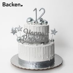 a white cake with silver decorations and the words happy birthday written on it