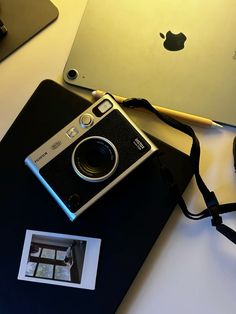 an old camera sitting on top of a table next to a laptop