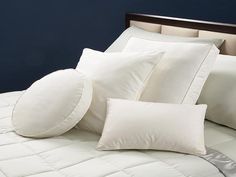 a bed with white pillows on top of it and a pillow case in the middle