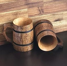 two wooden mugs sitting next to each other on a table