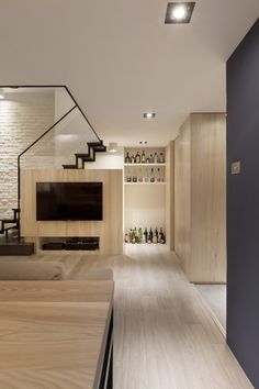 a living room filled with furniture and a flat screen tv on top of a wooden shelf