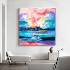 an abstract painting hangs on the wall in a living room with white furniture and chairs