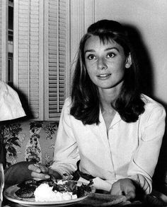 black and white photograph of two people sitting at a table with food in front of them