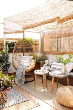 an outdoor living area with wicker furniture and potted plants on the roof terrace