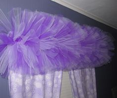 purple tulle skirt hanging from the side of a window