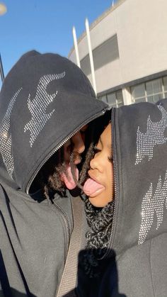 a woman sticking her tongue out while wearing a hoodie