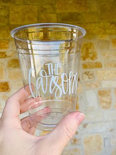 a person holding up a clear cup with the word casserole written on it