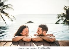 a man and woman sitting next to each other in a pool