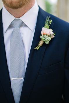 a man in a suit and tie with a boutonniere on his lapel