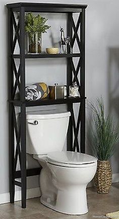 a toilet with a shelf above it in a bathroom next to a potted plant