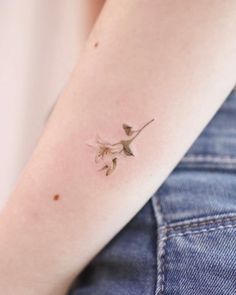 a small bird tattoo on the left arm