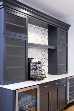 a coffee machine is sitting on the counter in front of some cupboards and drawers