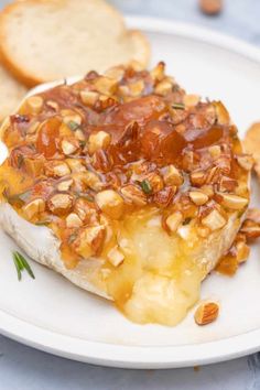 baked brie with apricot preserves, almonds and rosemary on a white plate