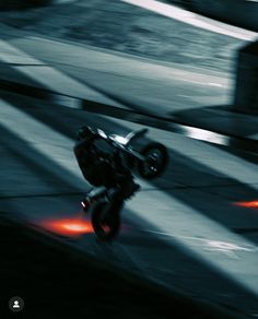 a motorcyclist is riding down the street at high speed with red lights